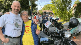 Zwei Männer posen vor einem Motorrad