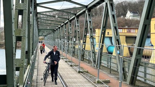 Passanten laufen über eine Brücke, die über den Hengsteysee führt