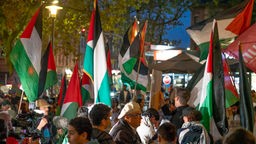 Demonstranten tragen palästinensische Fahnen
