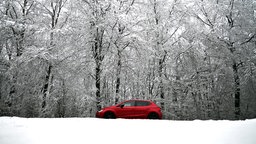 Rotes Auto fährt durch den Schnee