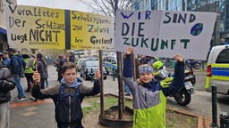 Schülerdemo gegen veraltertes Schulsystem: links Valentin (11) und rechts Lukas (10) aus Düsseldorf halten Plakate in die Luft