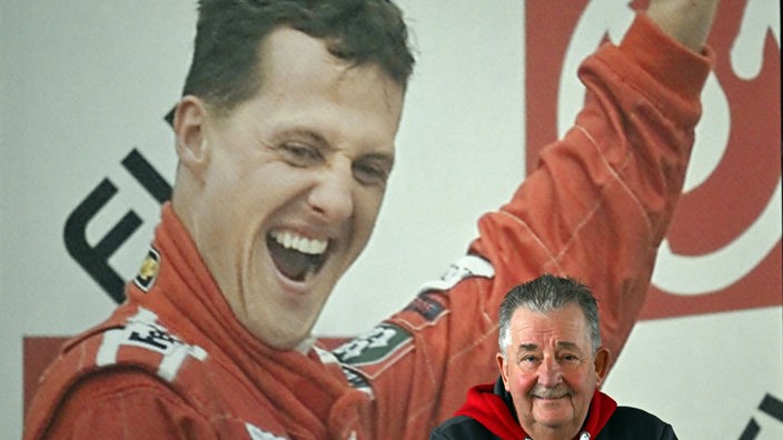Reiner Ferling, Vorsitzender des Michael und Mick Schumacher Fan-Club Kerpen, steht steht vor einem Foto von Michael Schumacher