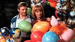 Uwe Friedrichsen und Liselotte Pulver  mit der Handpuppe Herr von Bödefeld sind umgeben von vielen Ballons