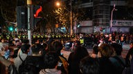 Menschen versammeln sich und protestieren gegen Chinas Null-Covid-Politik, während Polizeibeamte die Wulumuqi-Straße am 27. November 2022 in Shanghai blockieren