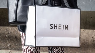 Eine Frau hält eine Einkaufstasche der Marke "Shein"
