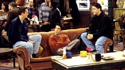 Matthew Perry, David Schwimmer und Matt LeBlanc auf Sofa in der Serie Friends