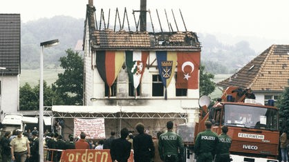 Polizeibeamten sichern die Trauerfeier vor dem ausgebrannten Haus, aufgenommen am 31.05.1993