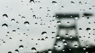 Regentropfen auf einer Autoscheibe, im Hintergrund ein Förderturm