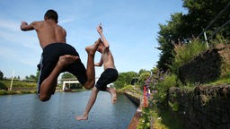 Zwei Jungen springen bei Sommerwetter in den Rhein Herne Kanal