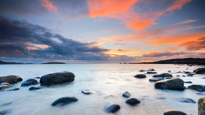 Sonnenuntergang an einem steinigen Sandstrand bei Achiltibuie an der Westküste Schottlands