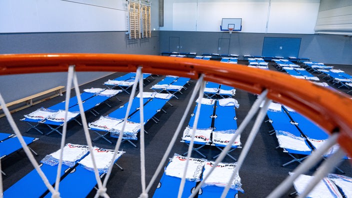 Sporthallen werden mit Feldbetten zur Notunterkunft für Flüchtlinge.