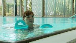 Eine Frau schwimmt in einem Schwimmbecken.