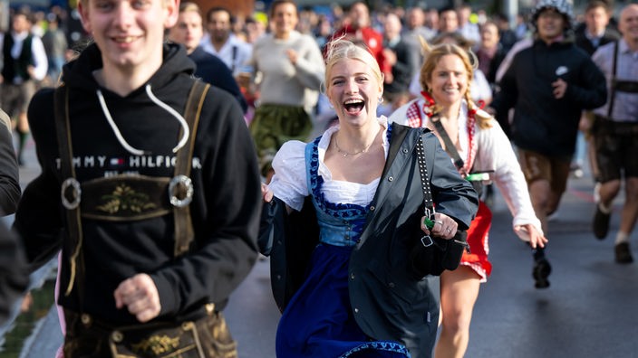 17.09.2022, Bayern, München: Die ersten Wiesnbesucher rennen nach dem Einlass zu den Festzelten