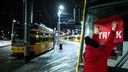 Rotes Streik-Plakat wird an Frontscheibe von Straßenbahn in Essen geklebt
