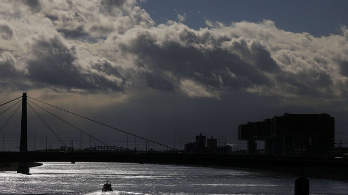 Köln: Wolken ziehen über den Rhein. Die Menschen in Nordrhein-Westfalen müssen sich in den kommenden Tagen auf stürmisches und ungemütliches Wetter einstellen