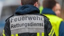 Symbolbild: Feuerwehrmann von hinten mit Schriftzug "Feuerwehr Rettungsdienst" auf dem Rücken