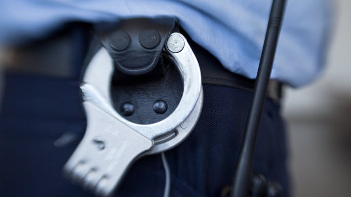 Gürtel eines Polizisten mit Handschellen und Funkgerät 