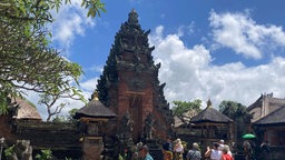 Touristen besuchen einen Tempel auf Bali