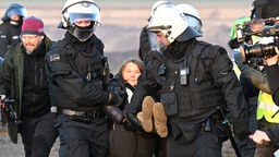 Polizisten tragen die schwedische Klimaaktivistin Greta Thunberg (M) aus einer Gruppe von Demonstranten und Aktivisten heraus