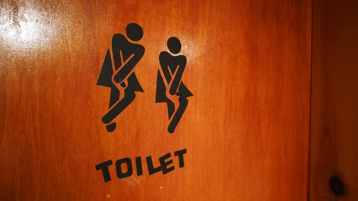 Tür zu einer Toilette mit Symbolaufkleber