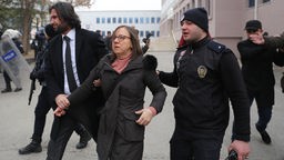 Akademikerin wird vor dem Universität verhaftet und abgeführt