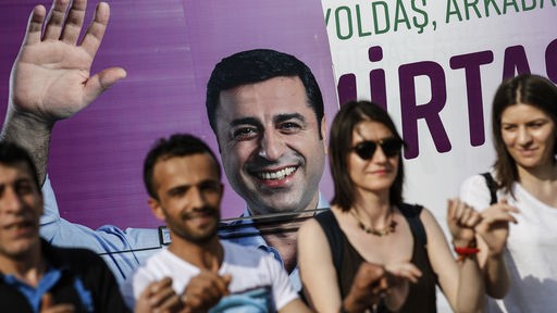 Türkei, Istanbul: Menschen tanzen vor einem Plakat des inhaftierten Präsidentschaftskandidaten Selahattin Demirtas von der pro-kurdischen Partei HDP