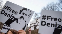 Menschen halten Plakate mıt der Losung 'Free Deniz" in die Luft. 
