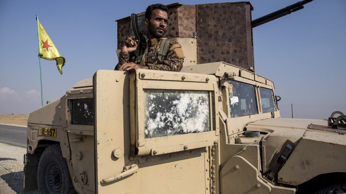 Amuda: Ein Soldat der Kurdenmiliz YPG schaut aus einem Militärfahrzeug, während er eine Waffe über der Schulter hält