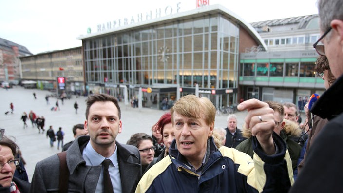 Peter Biesenbach steht in Köln vor dem Hauptbahnhof nebed em FDP Obmann Lürbke  und dem Polizeidirektor Georg Schulz  auf der Freitreppe 
