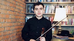 Der ukrainische Musiker und Geigenlehrer Andrij Derij mit seiner Geige in der Hand.