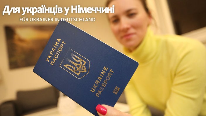 Eine Frau hält einen Pass der Ukraine in der Hand. Auf dem Bild steht der Schriftzug: Українці в ПРВ / Ukrainer in NRW