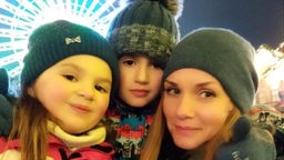 Die Ukrainerin Tetiana mit ihrem Sohn und Tocher auf einer Kirmes