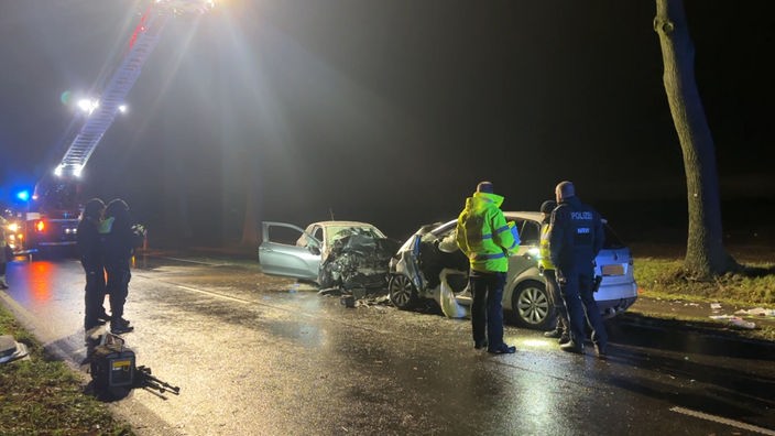 Zwei schwerbeschädigte Autos stehen am Straßenrand der K1 zwischen Tüddern und Millen