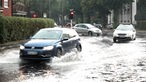 Autos fahren durch eine überflutete Straße
