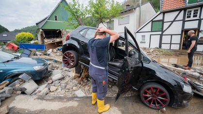 Hagen: Ein Anwohner steht vor seinem zerstörten Auto im Ortsteil Hohenlimburg