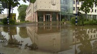 Die Fassade eines Seniorenzentrums spiegelt sich nach dem Unwetter in Fröndenberg im Wasser