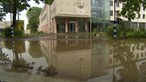 Die Fassade eines Seniorenzentrums spiegelt sich nach dem Unwetter in Fröndenberg im Wasser
