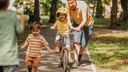 Vater hilft seinem Kind beim Fahrradfahren