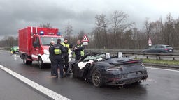 Ein schwer beschädigter Porsche auf der Autobahn.