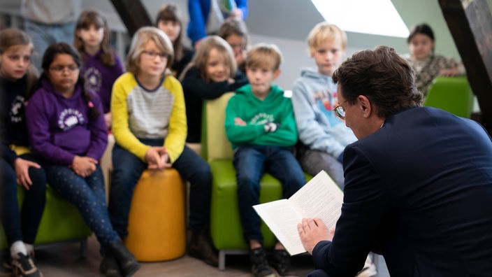 Ministerpraesident Hendrik Wüst (CDU) von Nordrhein-Westfalen liest Schülern im Rahmen des bundesweiten Vorlesetages aus dem Buch Ronja die Räubertochter vor