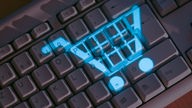 Online-Shopping: Einkaufswagen-Symbol auf einer Tastatur.  
