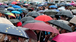 Publikum bei Wahlveranstaltung im Regen 