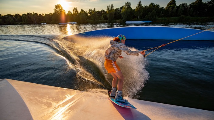 Ein Wakeboarder rutscht über eine Rampe