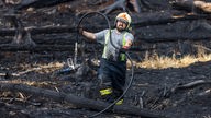 Ein Feuerwehrmann im Einsatz bei einem Waldbrand im Nationalpark Böhmische Schweiz