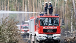 Löscharbeiten der Feuerwehr in einem an Brandenburg angrenzenden Waldbrandgebiet