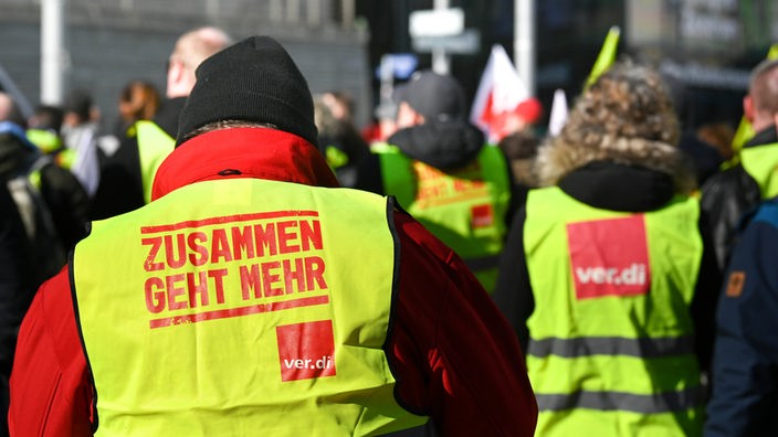 : Kommunale Beschäftigte tragen bei einem Warnstreik während einer Kundgebung auf dem Riebeckplatz Westen der Gewerkschaft Verdi mit der Aufschrift "Zusammen geht mehr"