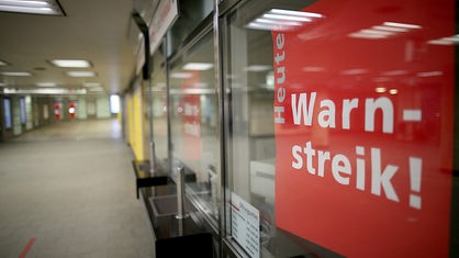 Köln: Plakate mit der Aufschrift "Heute Warnstreik" hängen an einem Ticketschalter.