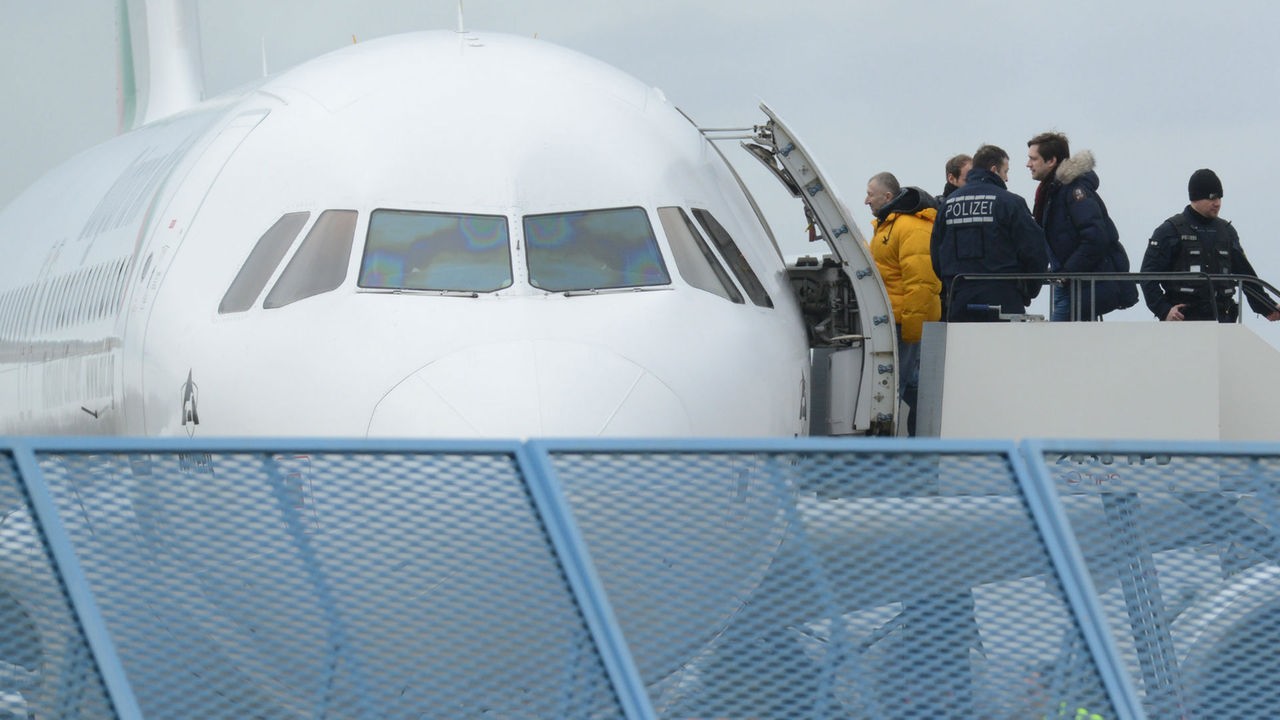 Abgelehnte Asylbewerber steigen in ein Flugzeug ein.