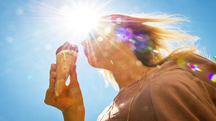 Junge Frau mit Eis vor strahlender Sonne