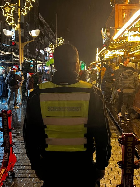 Duisburger Weihnachtsmarkt: Eingangsbereich mit Stahlbarrieren und Sicherheitskraft